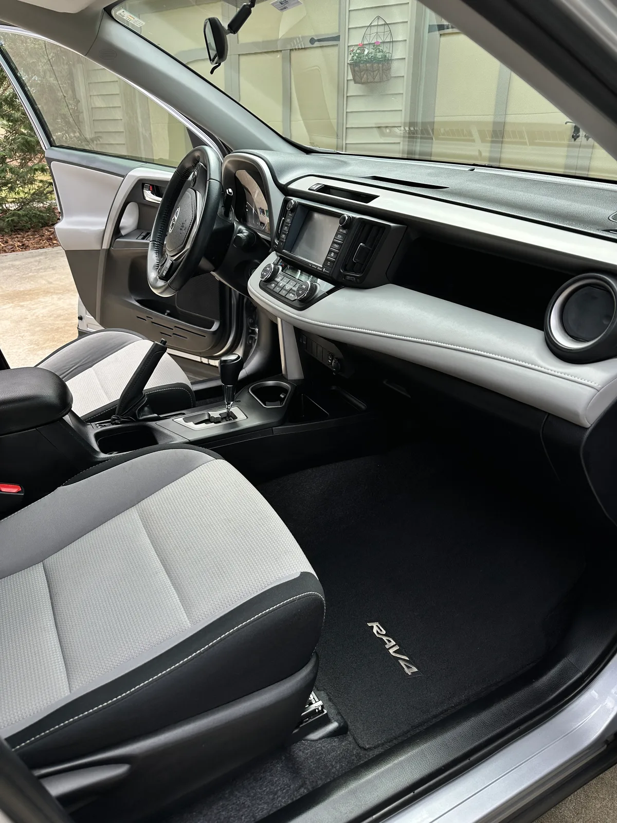 Silver SUV floor mat area after detail — clean carpet and door sill