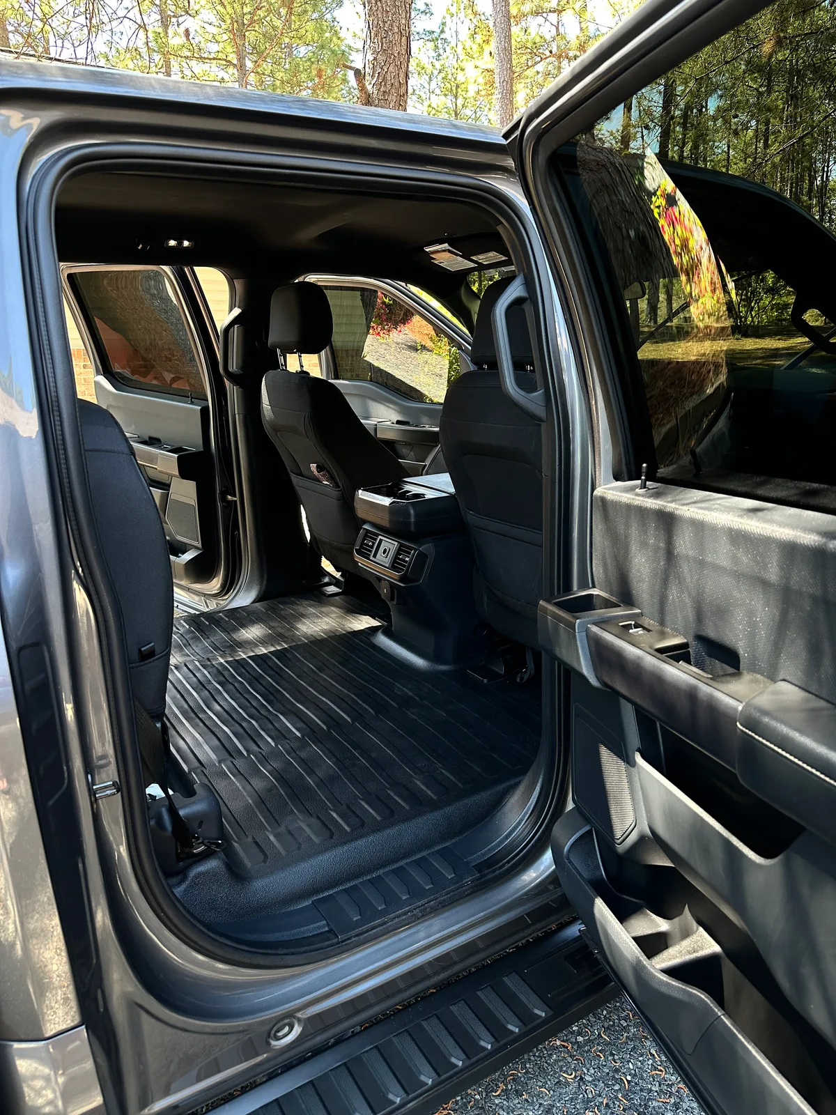 Dark SUV cargo bay after interior detail — deep cleaned floor liner and rear seat backs