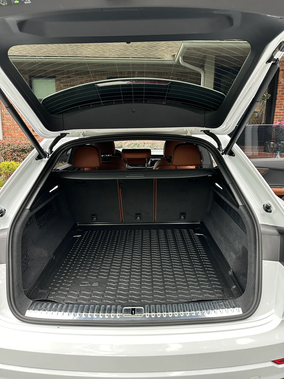 White luxury SUV cargo area after interior detail — clean tan leather and trunk liner