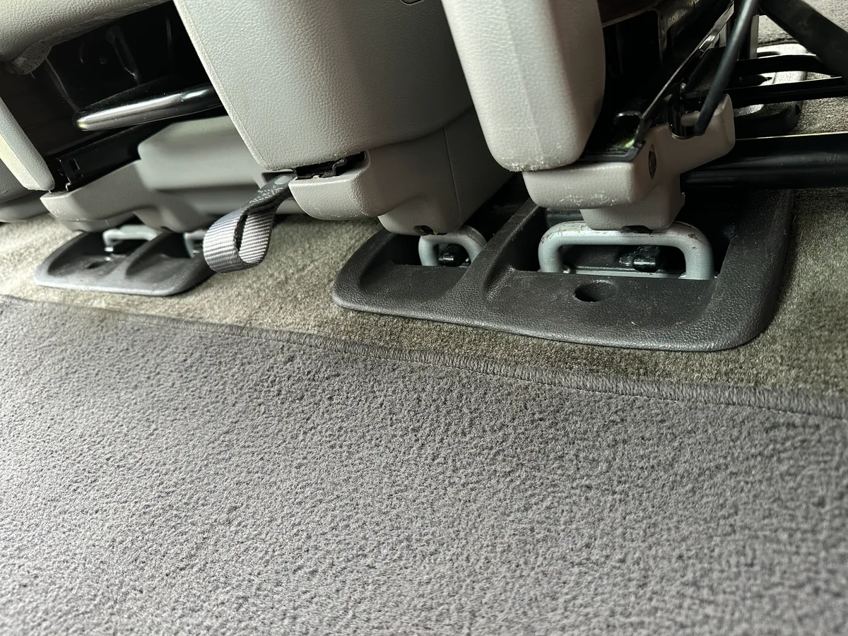Vehicle interior carpet after detail — deep cleaned floor and seat anchors